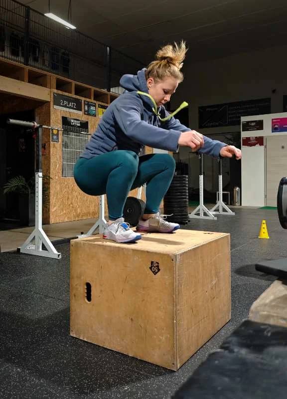 Sprung auf die Box im Einsteigertraining, konzentrierte Landung